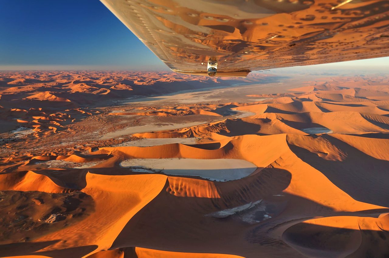 Aerial view over the red dunes and white pans of Sossusvlei, seen from a light aircraft